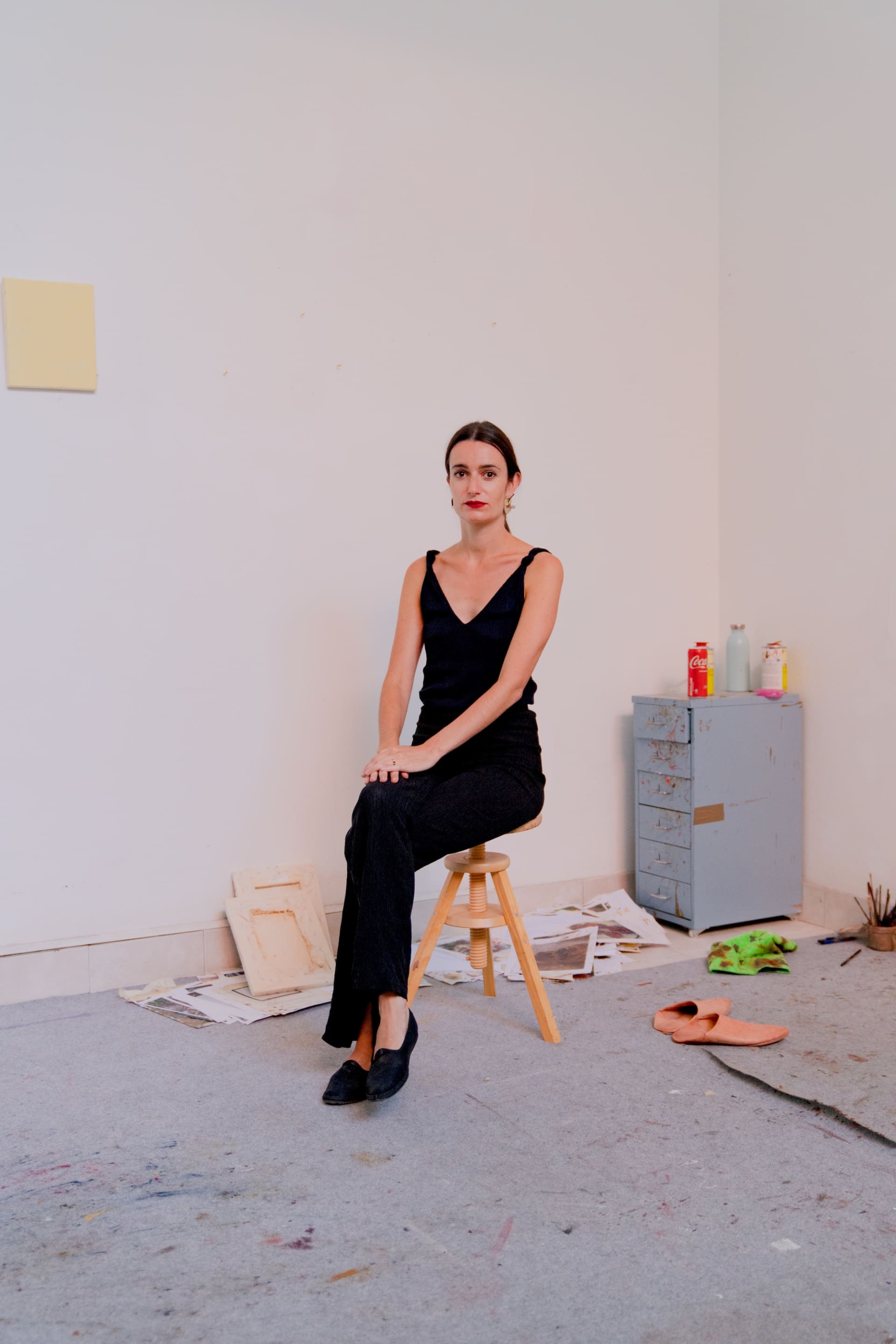 A portrait of Marta Ravasi sat on a stool in her studio