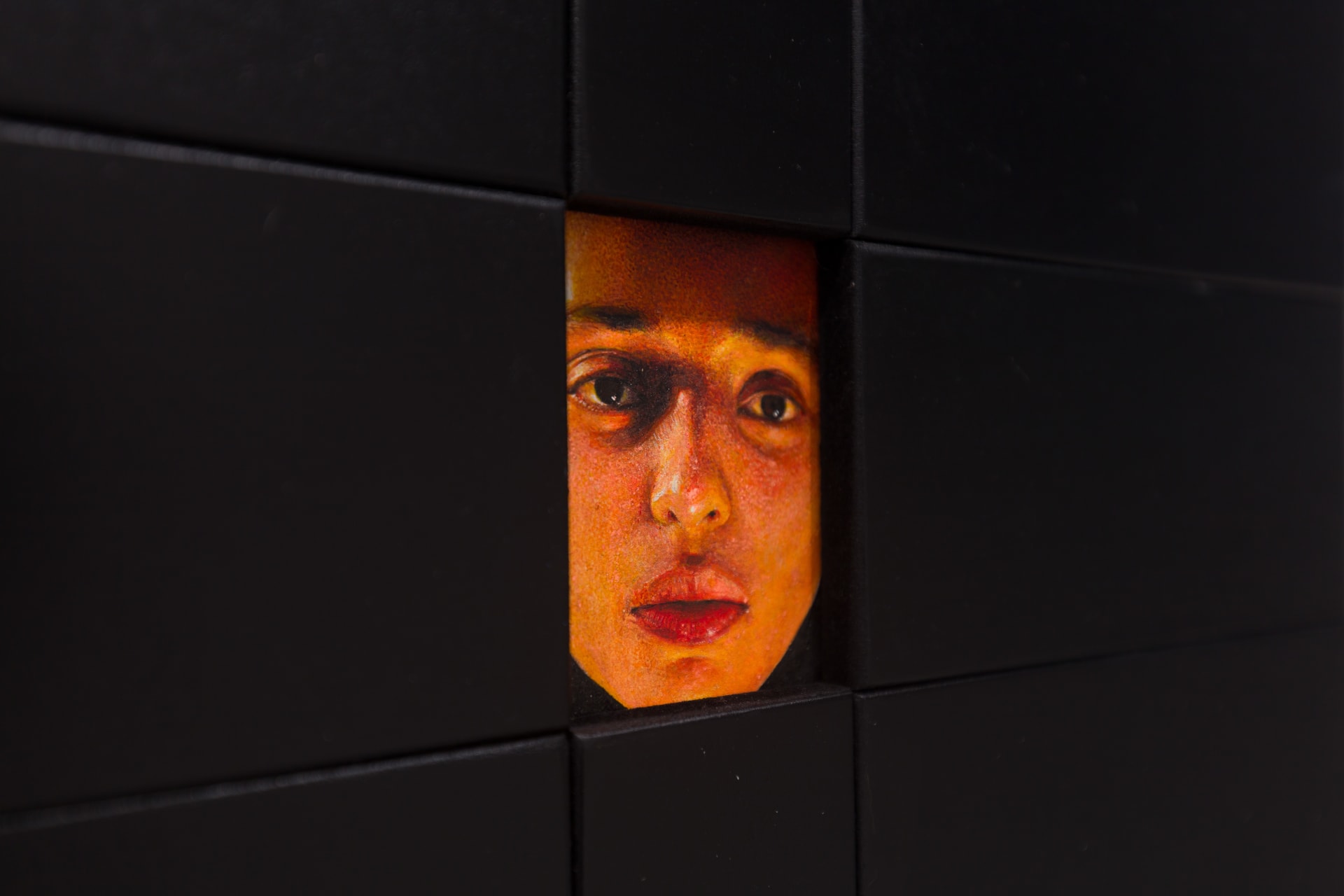 A painting by Ki Yoong of a woman's face framed within a large black wooden frame