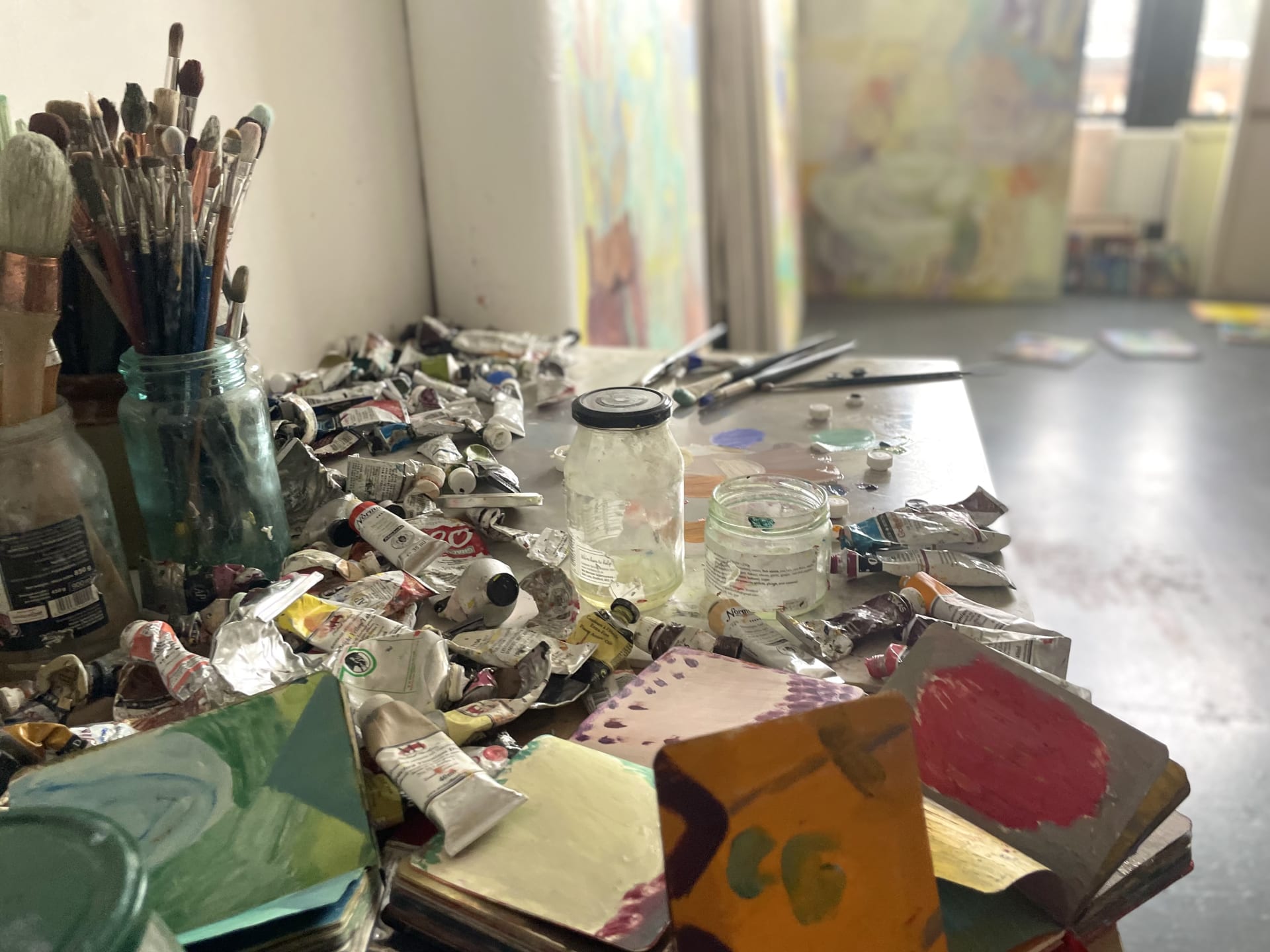 A table with paint and sketchbooks in Amy Winstanley's studio