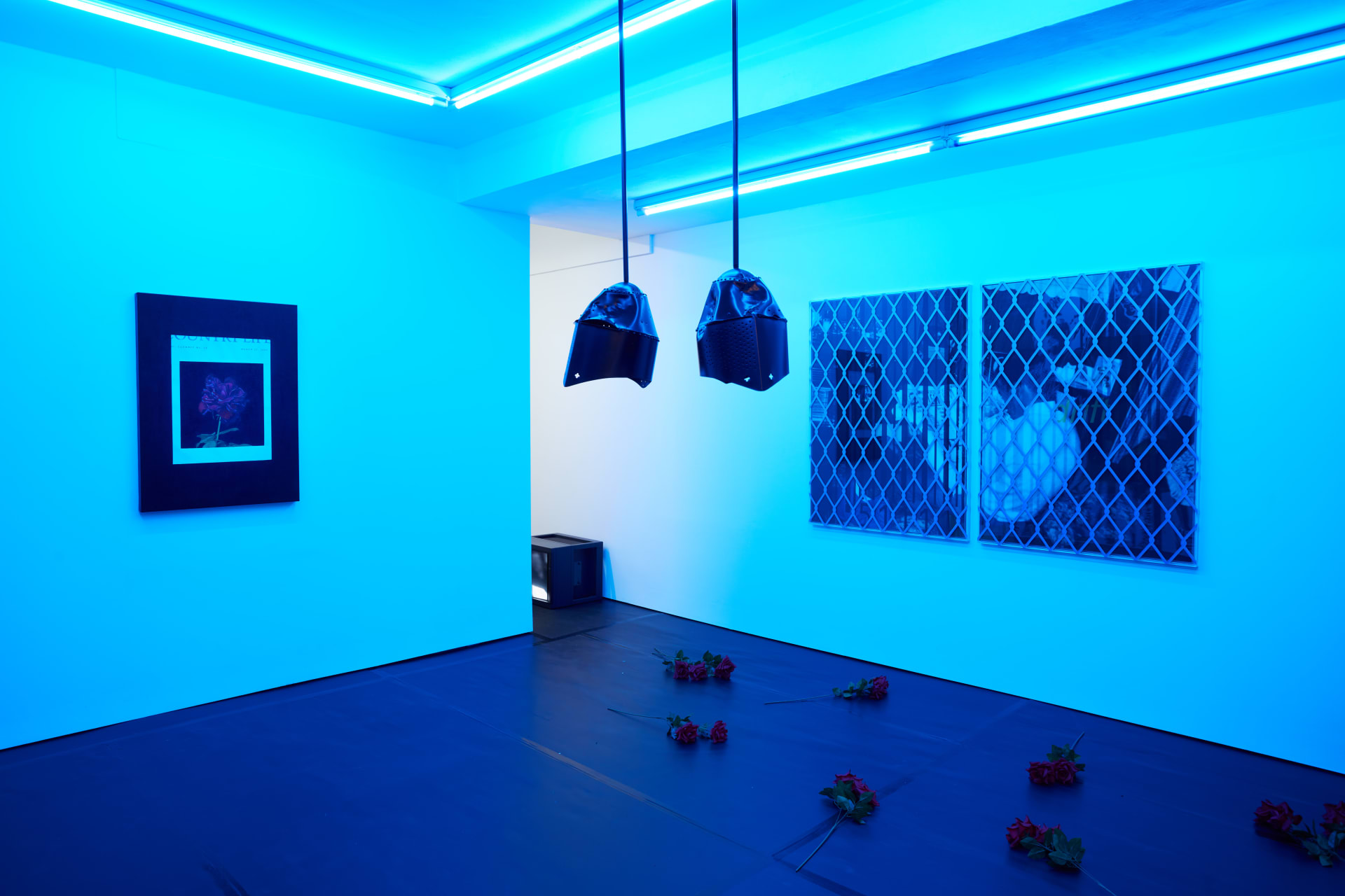 Installation images of Simeon Barclay's exhibition at Workplace in London, artworks, sculpture and video are cast in filtered blue light of a night club