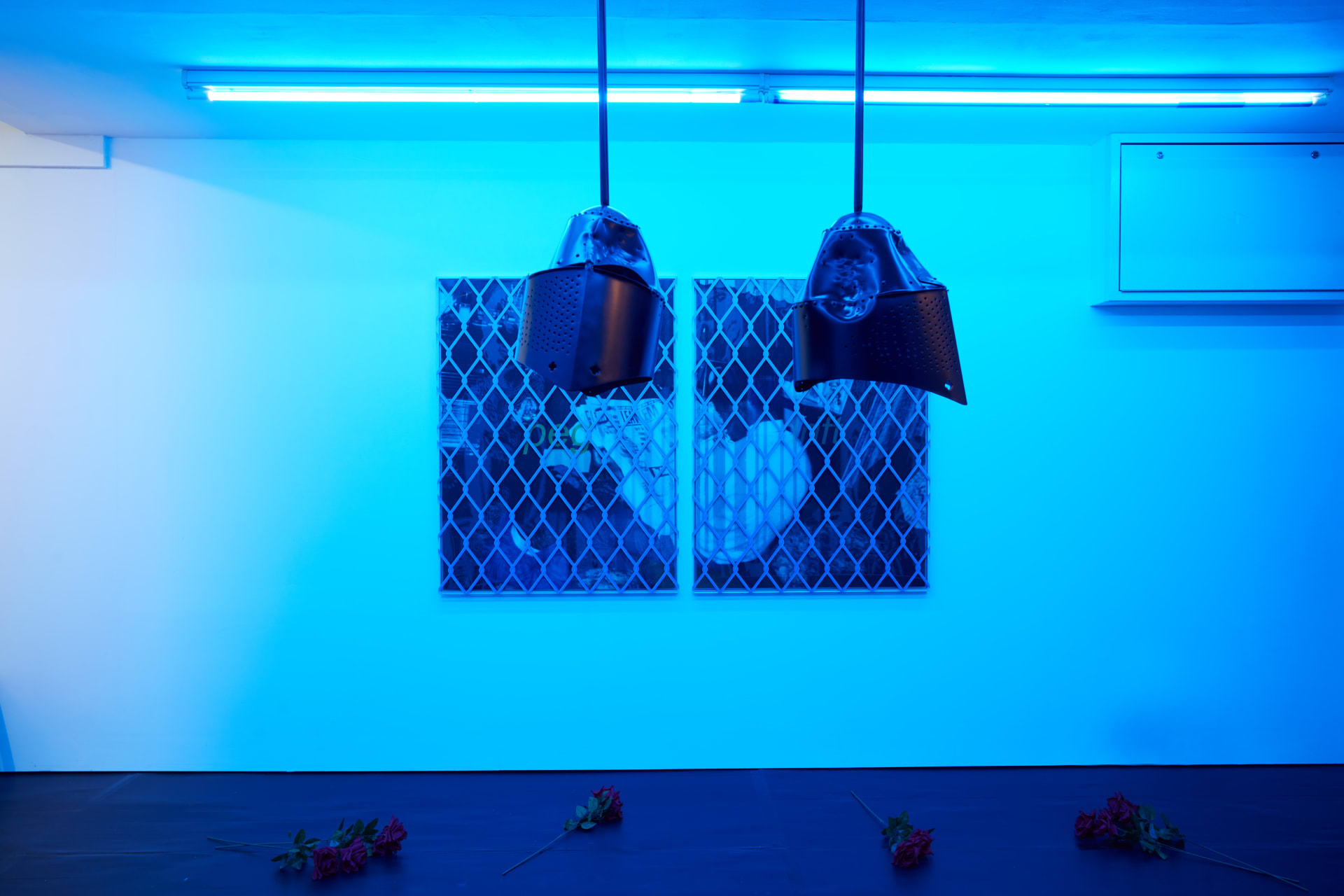 Installation images of Simeon Barclay's exhibition at Workplace in London, artworks, sculpture and video are cast in filtered blue light of a night club