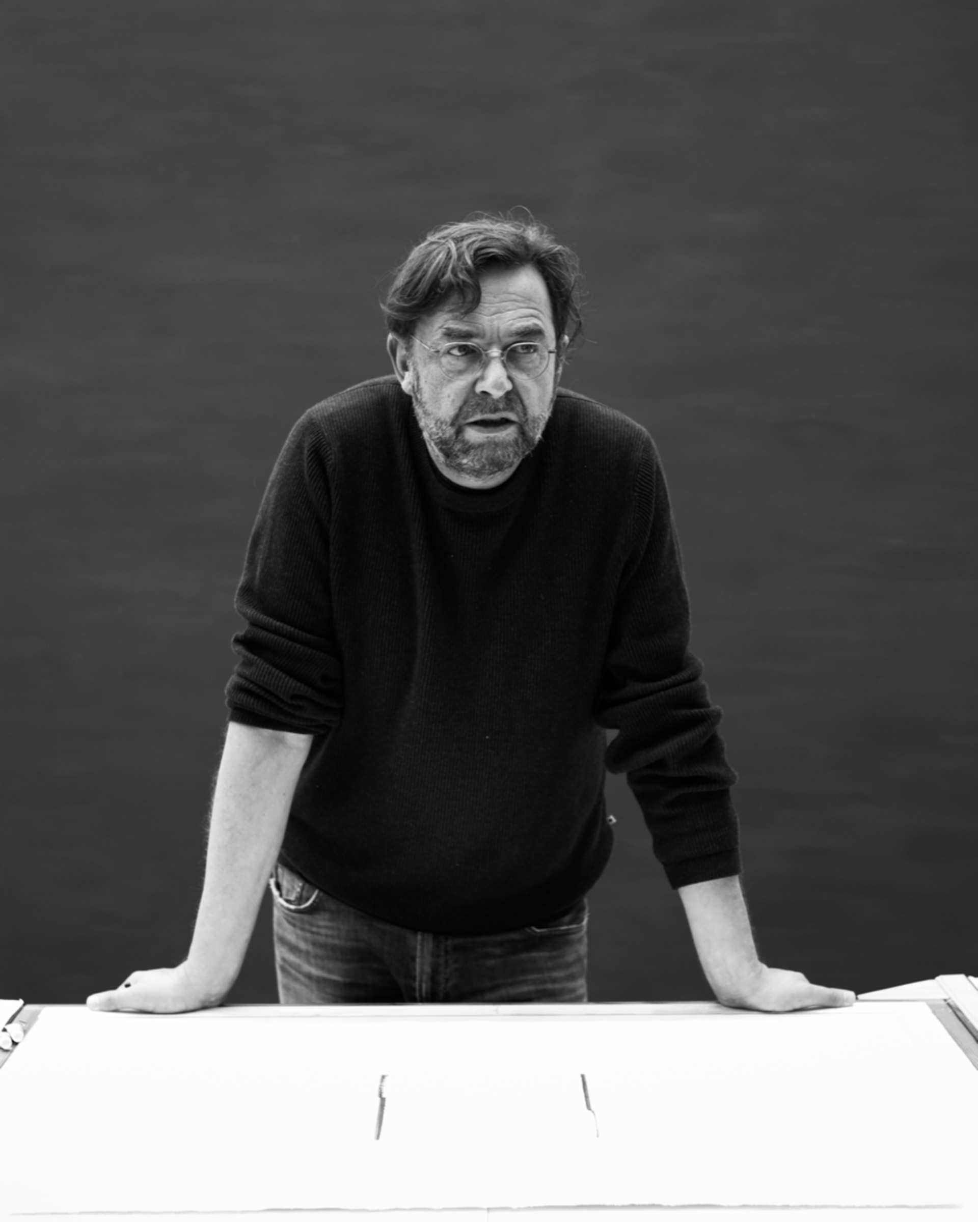 A black and white portrait of Calum Innes leaning on a table 