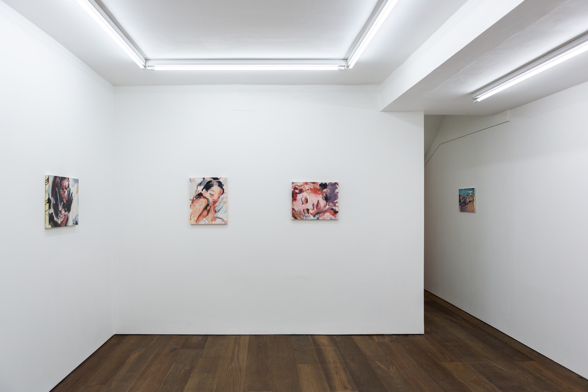 Installation shots of Laura Lancaster's solo show at Workplace London. Close up crop paintings of sleeping women and figures in landscapes, loosely painted.