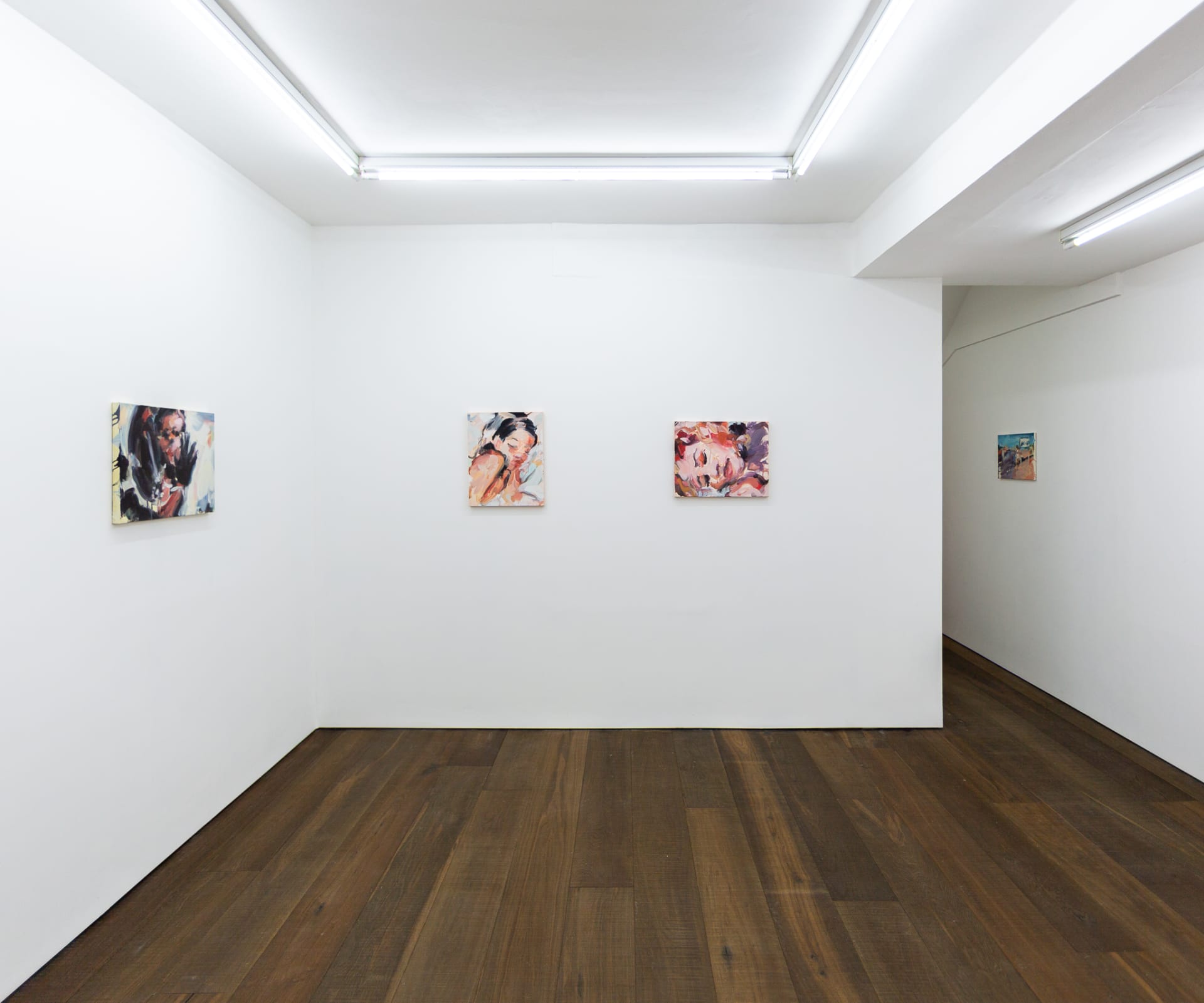 Installation shots of Laura Lancaster's solo show at Workplace London. Close up crop paintings of sleeping women and figures in landscapes, loosely painted.