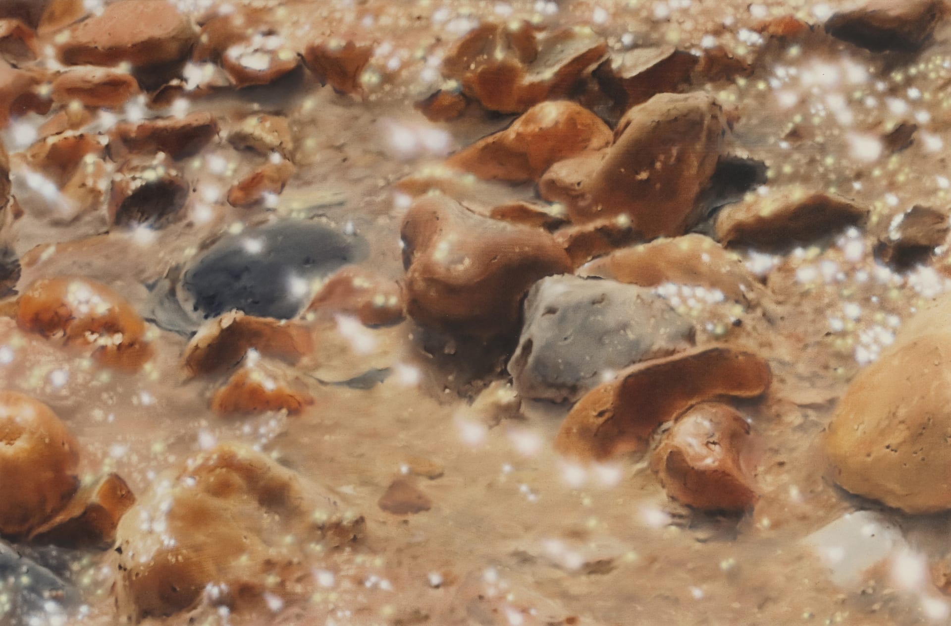 A detail of a painting by James Prapaithong of rocks on samd with bright sunshine reflecting off the water