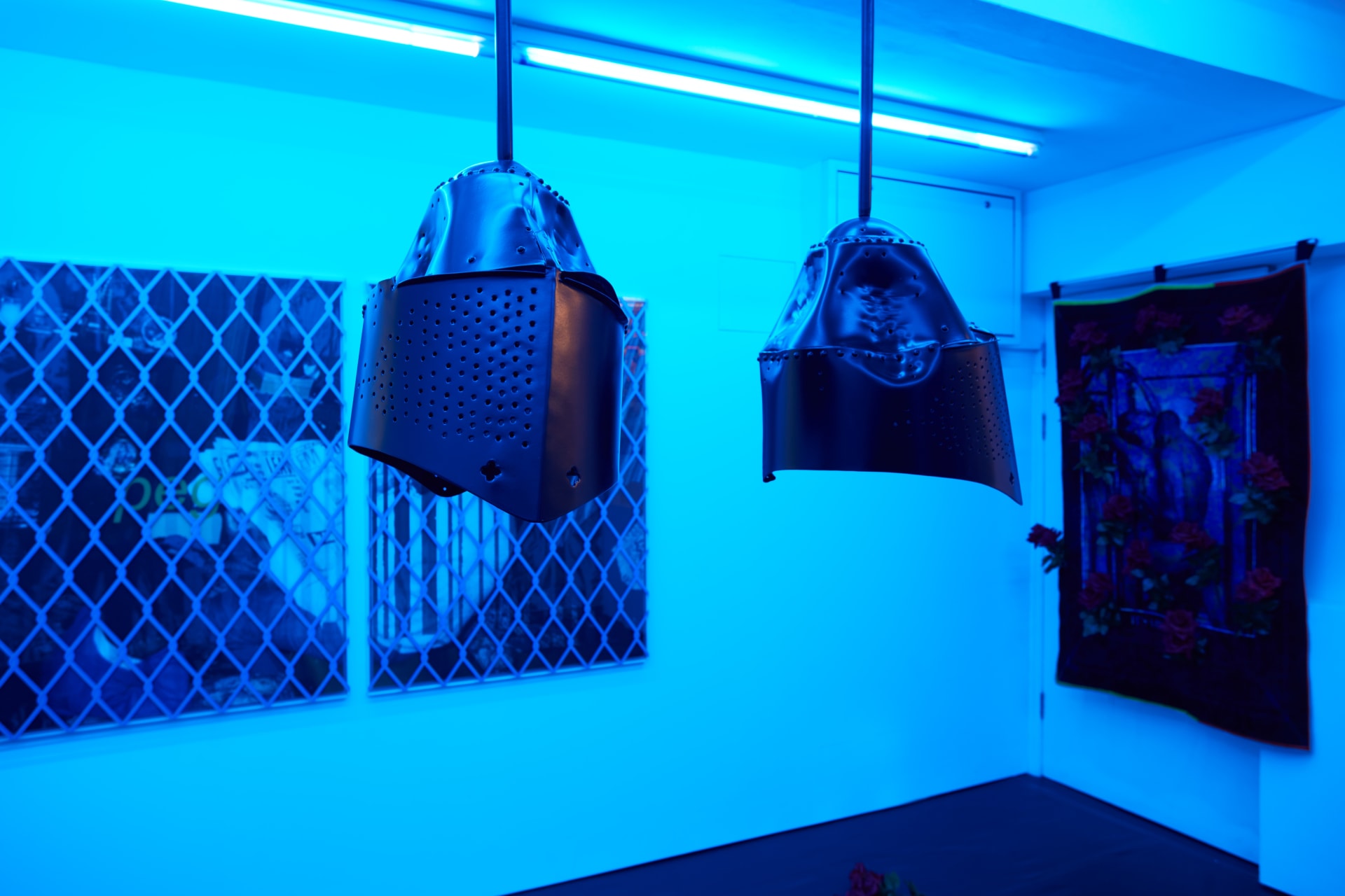 Installation images of Simeon Barclay's exhibition at Workplace in London, artworks, sculpture and video are cast in filtered blue light of a night club