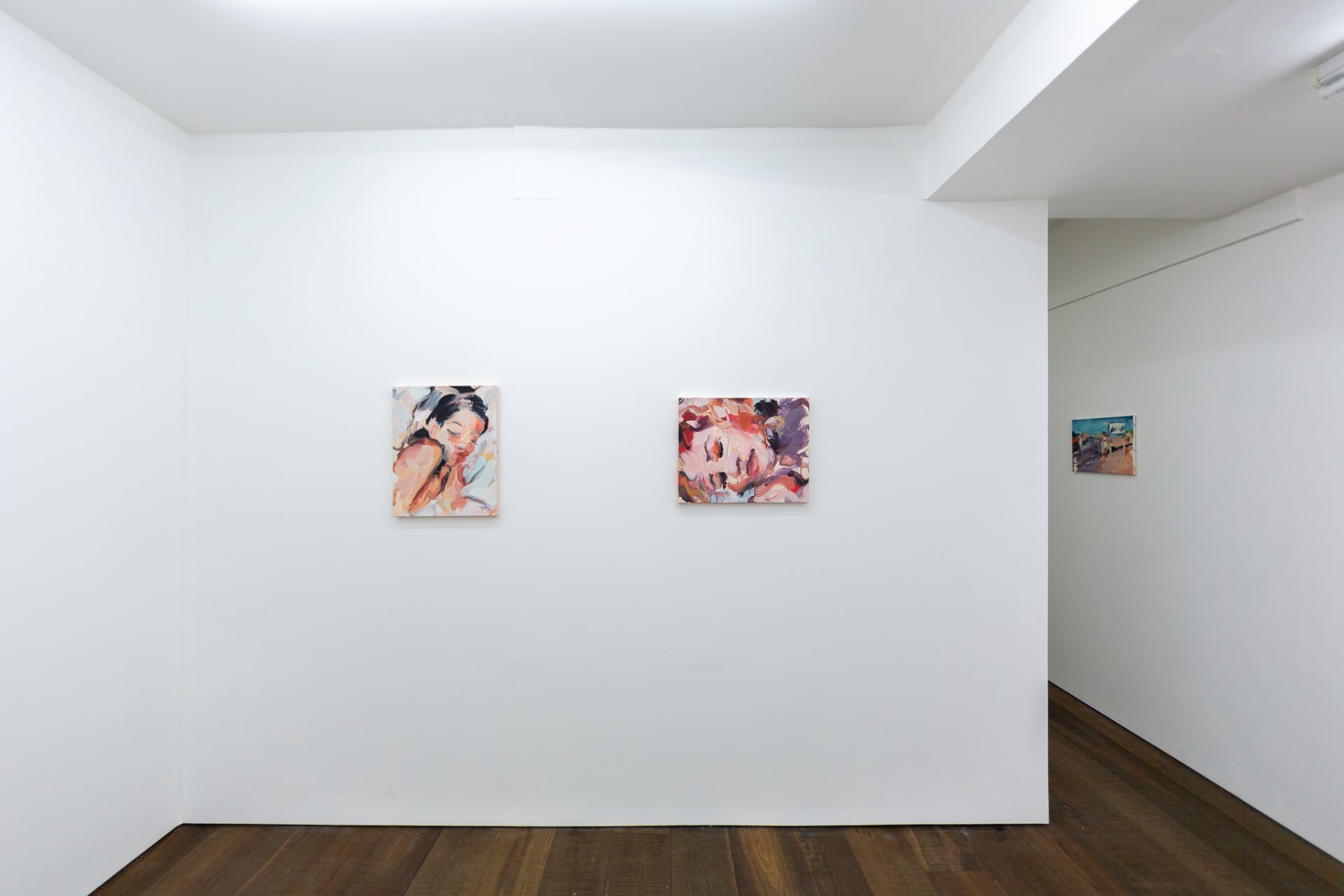 Installation shots of Laura Lancaster's solo show at Workplace London. Close up crop paintings of sleeping women and figures in landscapes, loosely painted.
