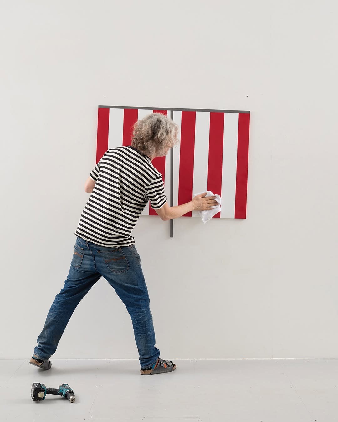 Jacob Dahlgren installing a wall based sculpture in a white gallery