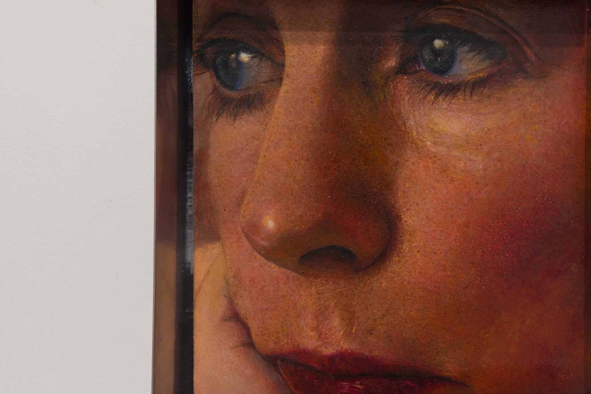 A painting by Ki Yoong of a woman's face enclosed in a stainless steel box