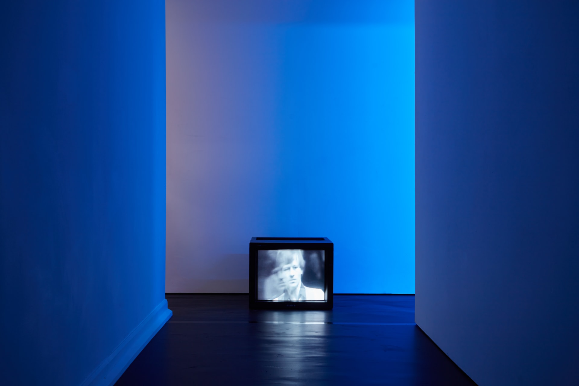 Installation images of Simeon Barclay's exhibition at Workplace in London, artworks, sculpture and video are cast in filtered blue light of a night club