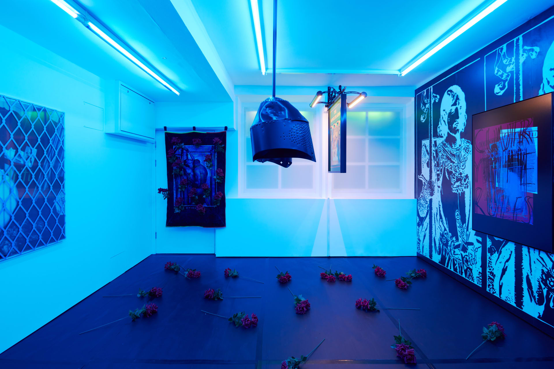 Installation images of Simeon Barclay's exhibition at Workplace in London, artworks, sculpture and video are cast in filtered blue light of a night club