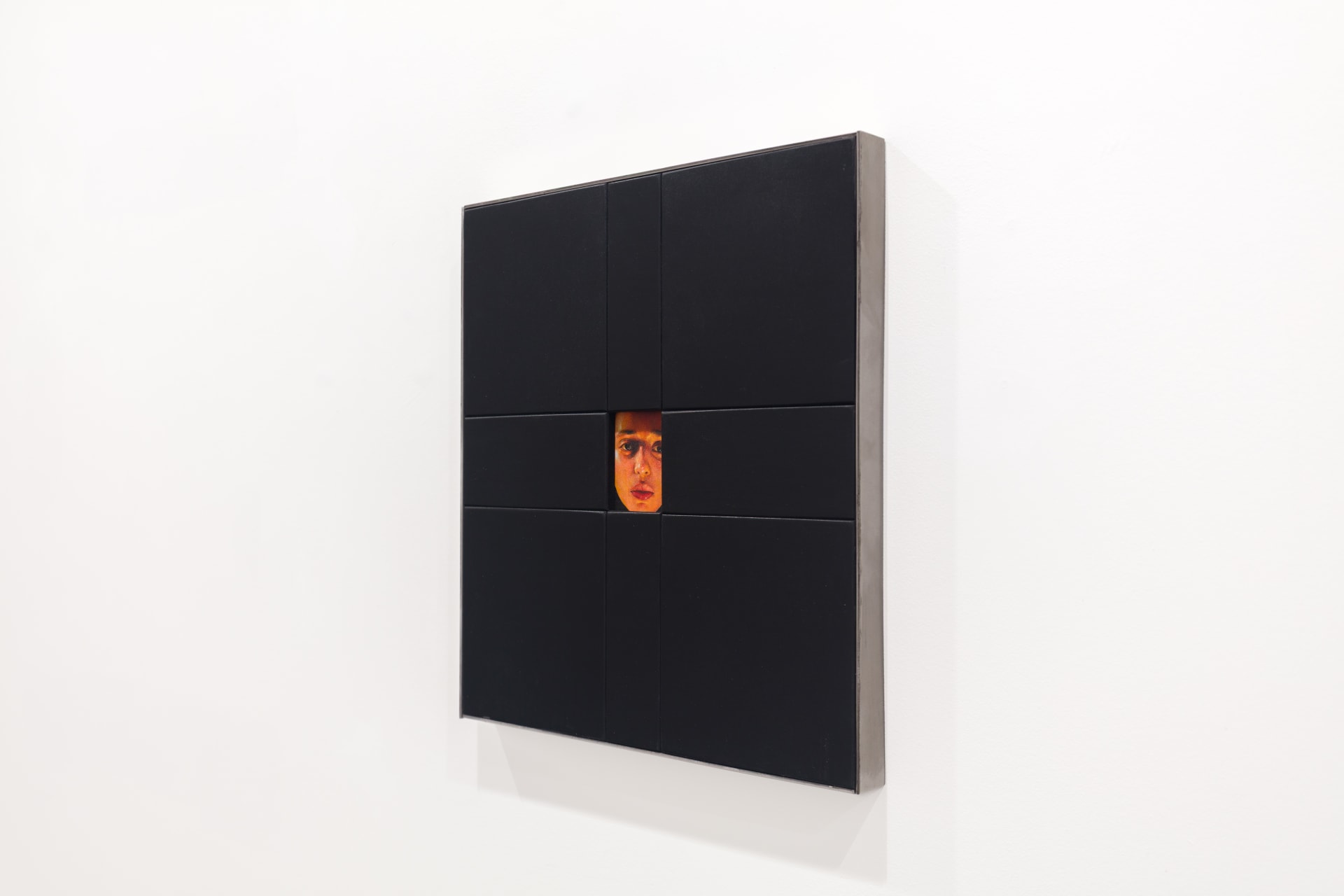 A painting by Ki Yoong of a woman's face framed within a large black wooden frame
