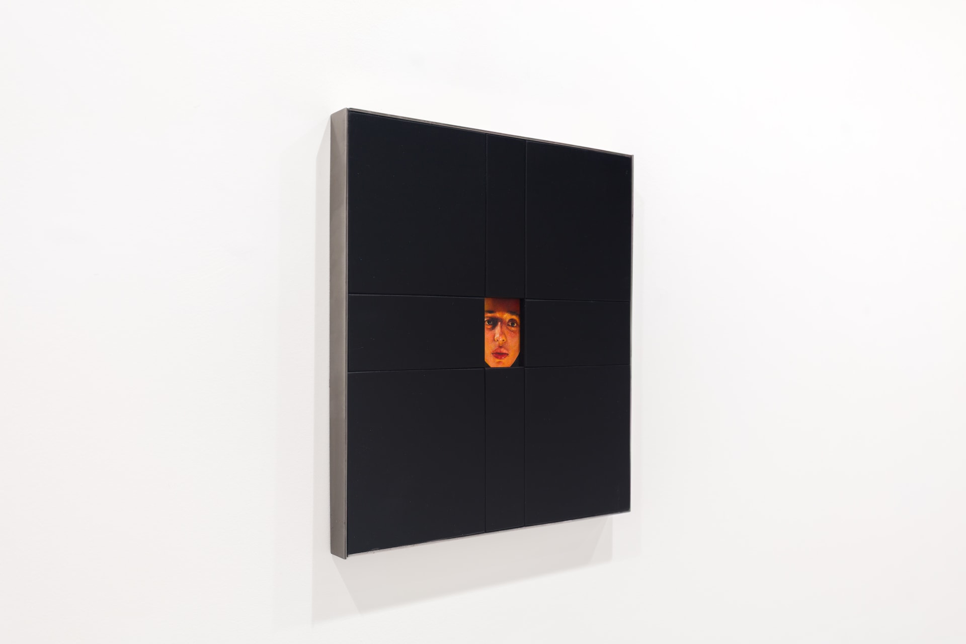 A painting by Ki Yoong of a woman's face framed within a large black wooden frame