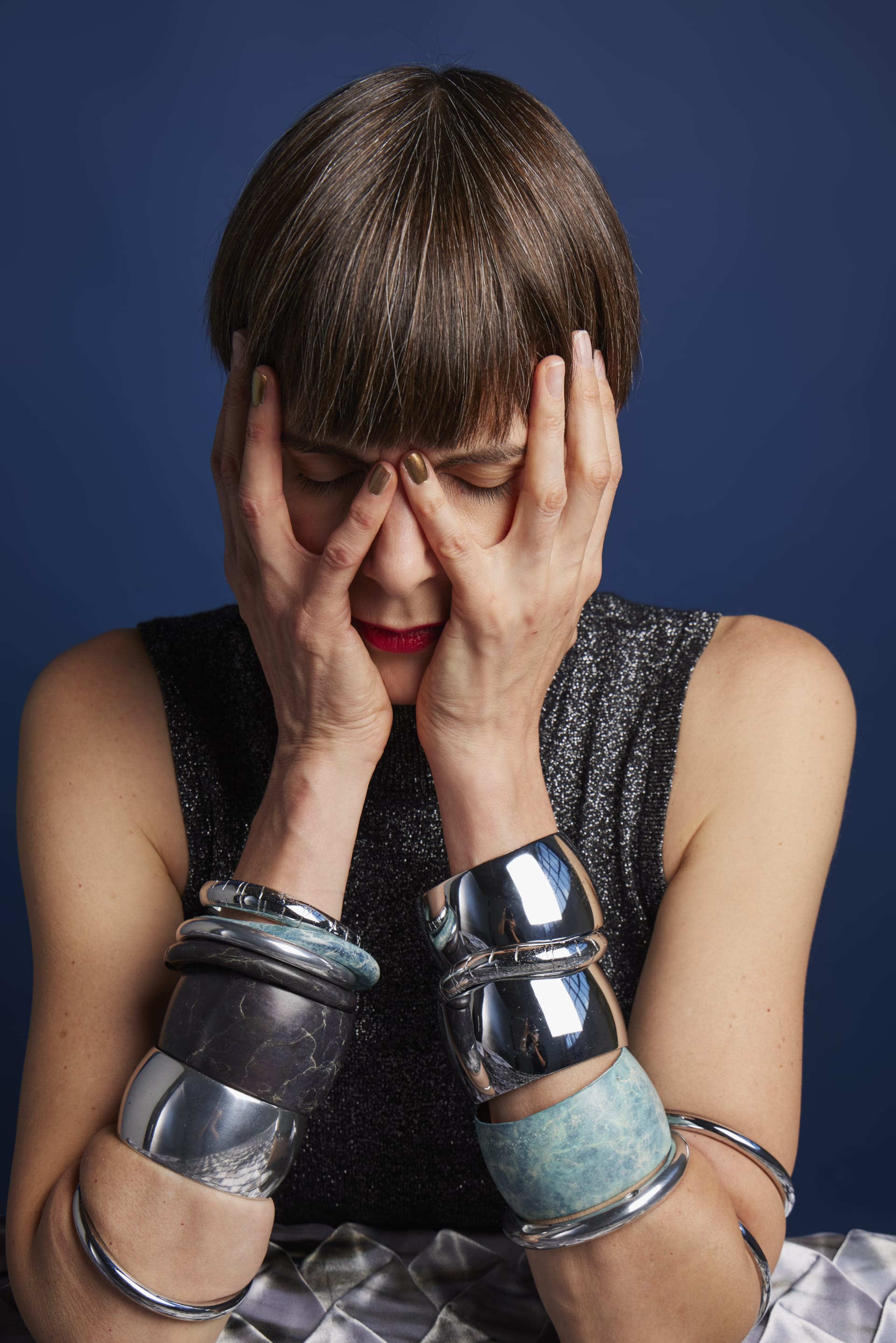 A portrait of Alice Channer covering her face with her hands