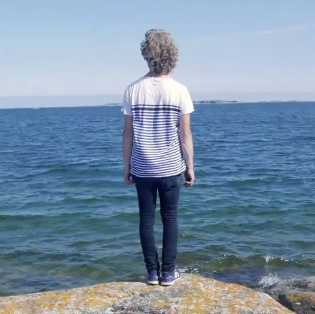 Jacob Dahlgren in a striped shirt in front of the sea