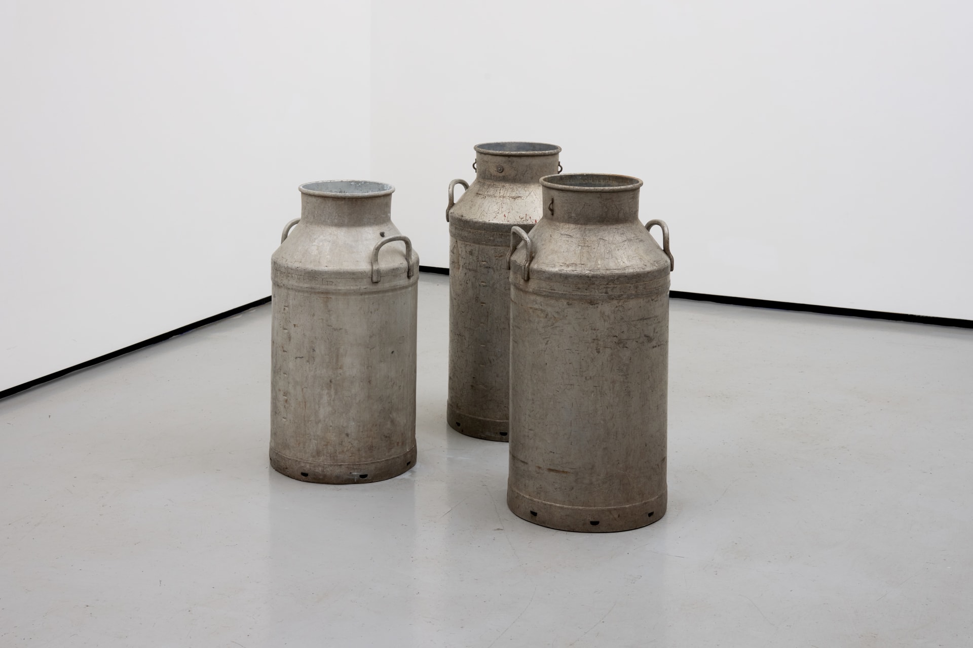 an image of a sculpture consisting of 3 milk churns full of fake milk