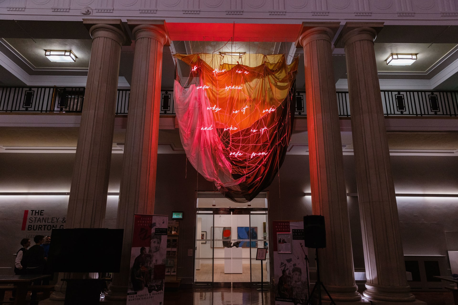 An installation by Simeon Barclay of a hanging parachute with red neon words