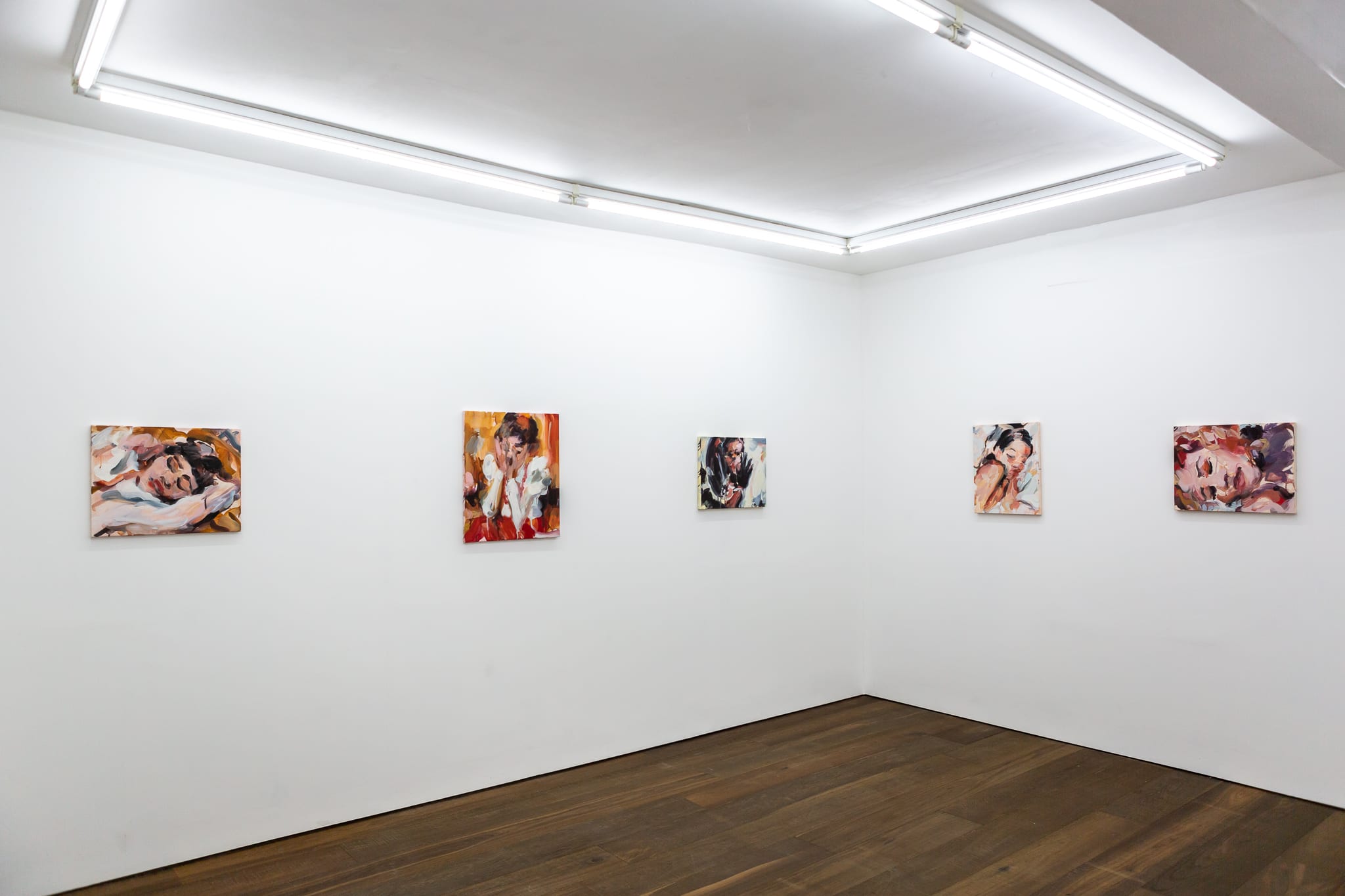 Installation shots of Laura Lancaster's solo show at Workplace London. Close up crop paintings of sleeping women and figures in landscapes, loosely painted.
