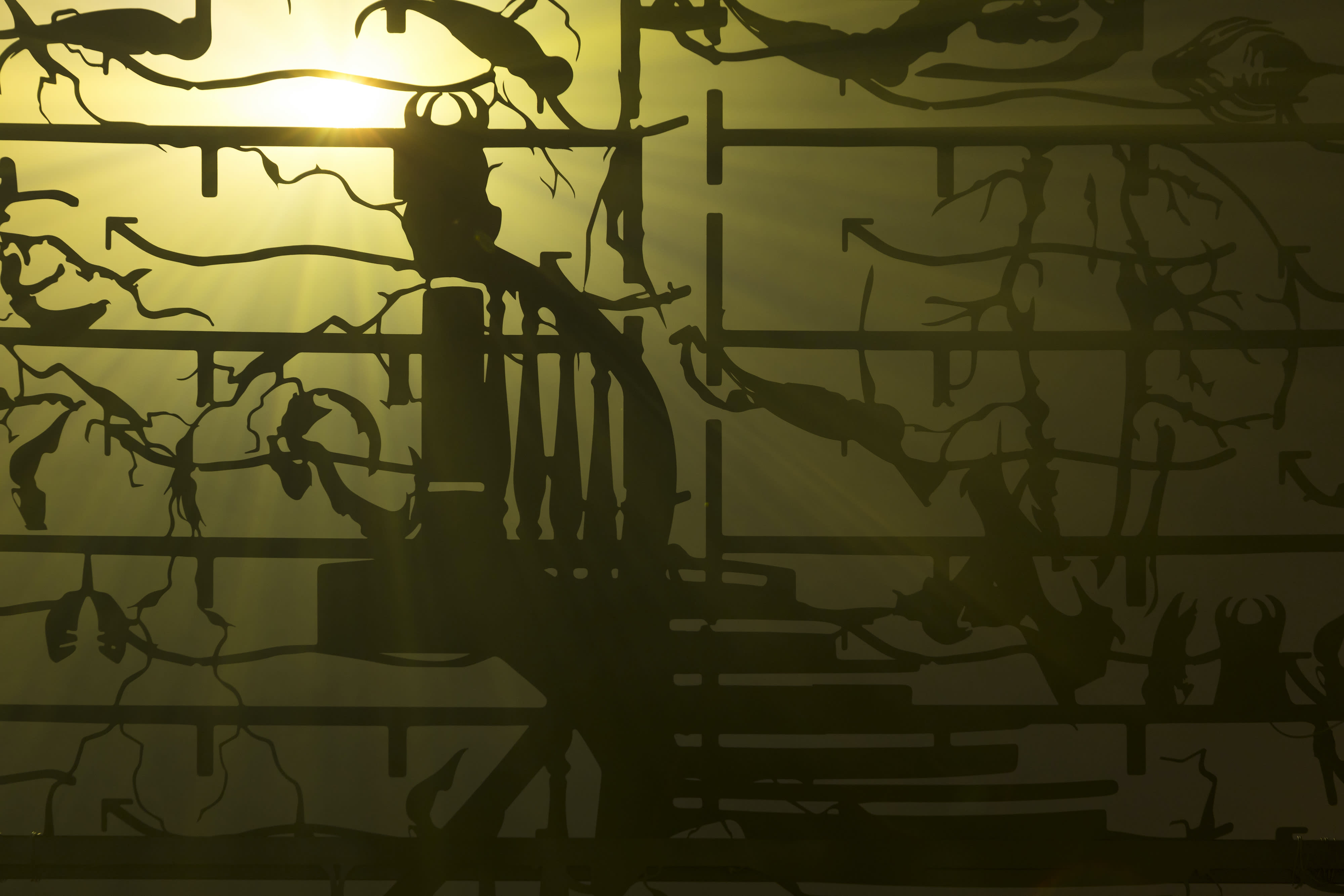 An installation by Hazel Brill including a water tanks filled with a dark liquid laser cut steel dividers, mouth-blown glass objects, projections and lights