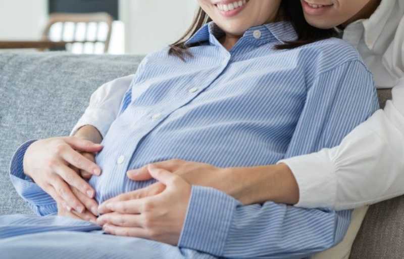 妊娠中の妻のお腹に手をあてる夫婦