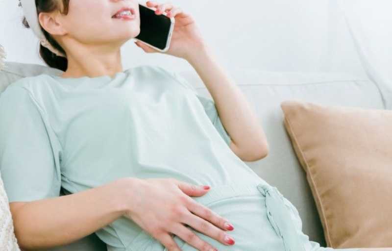 病院に電話する妊婦