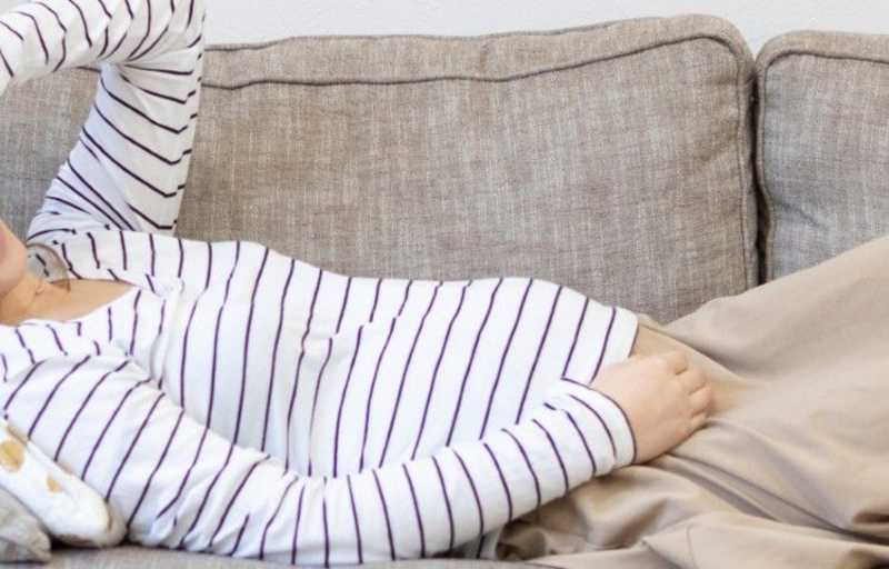 ソファーで安静にする妊婦