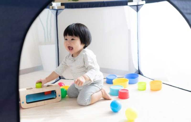 ベビーサークルで遊ぶ子ども
