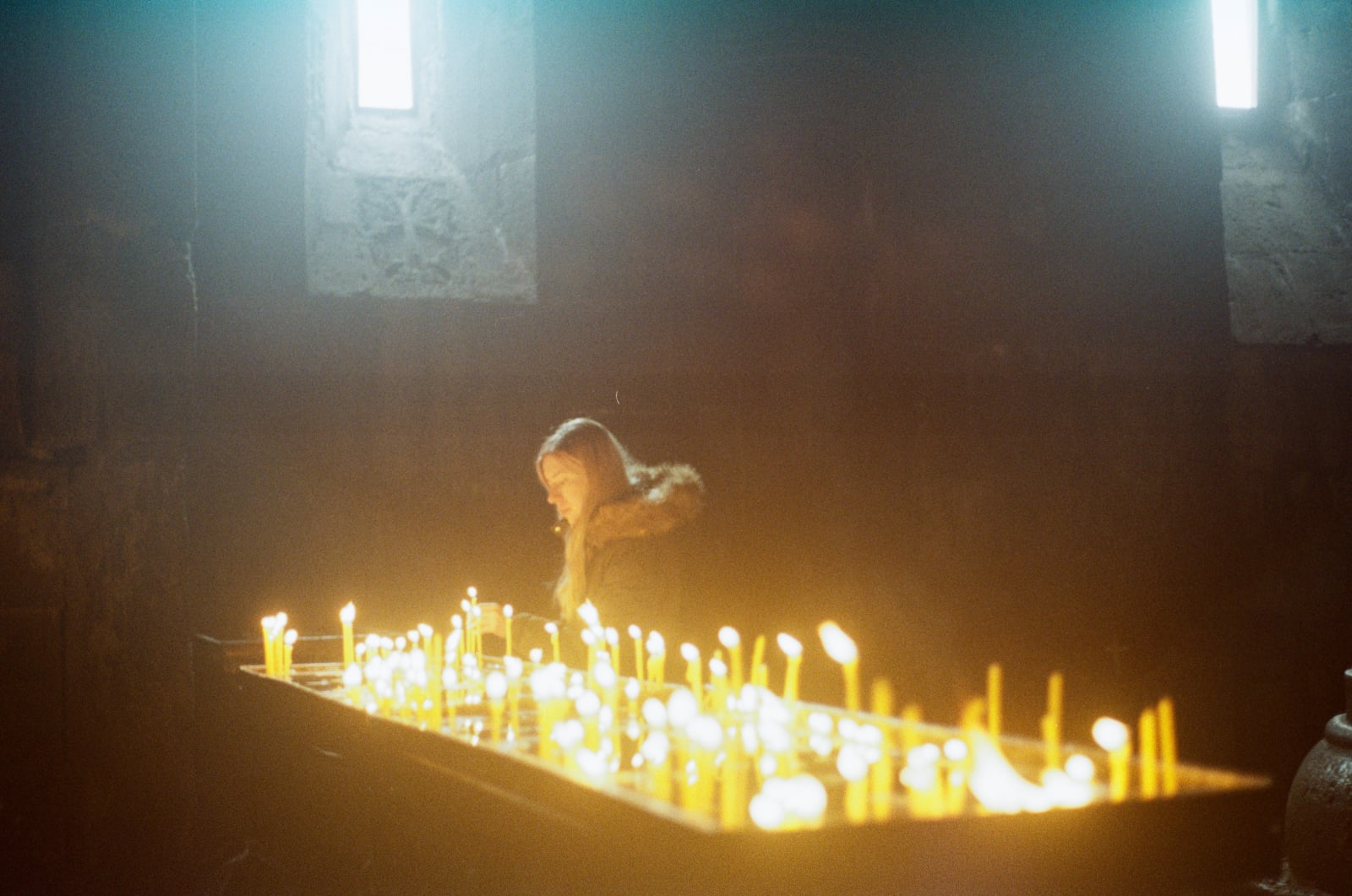 Janita lighting a candle in the Geghard Monastery