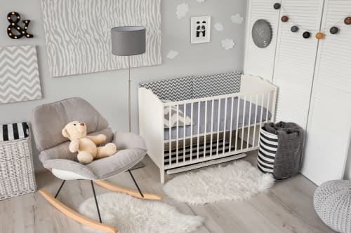 Lit De Bébé Classique Et Confortable Dans Une Chambre De Bébé Lumineuse  Avec Des Jouets Sur Un Tapis Moelleux Et Un Panier Tressé Dans Le Coin