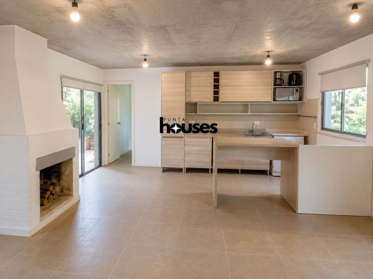 Open-plan living area with wood-burning fireplace and integrated kitchen