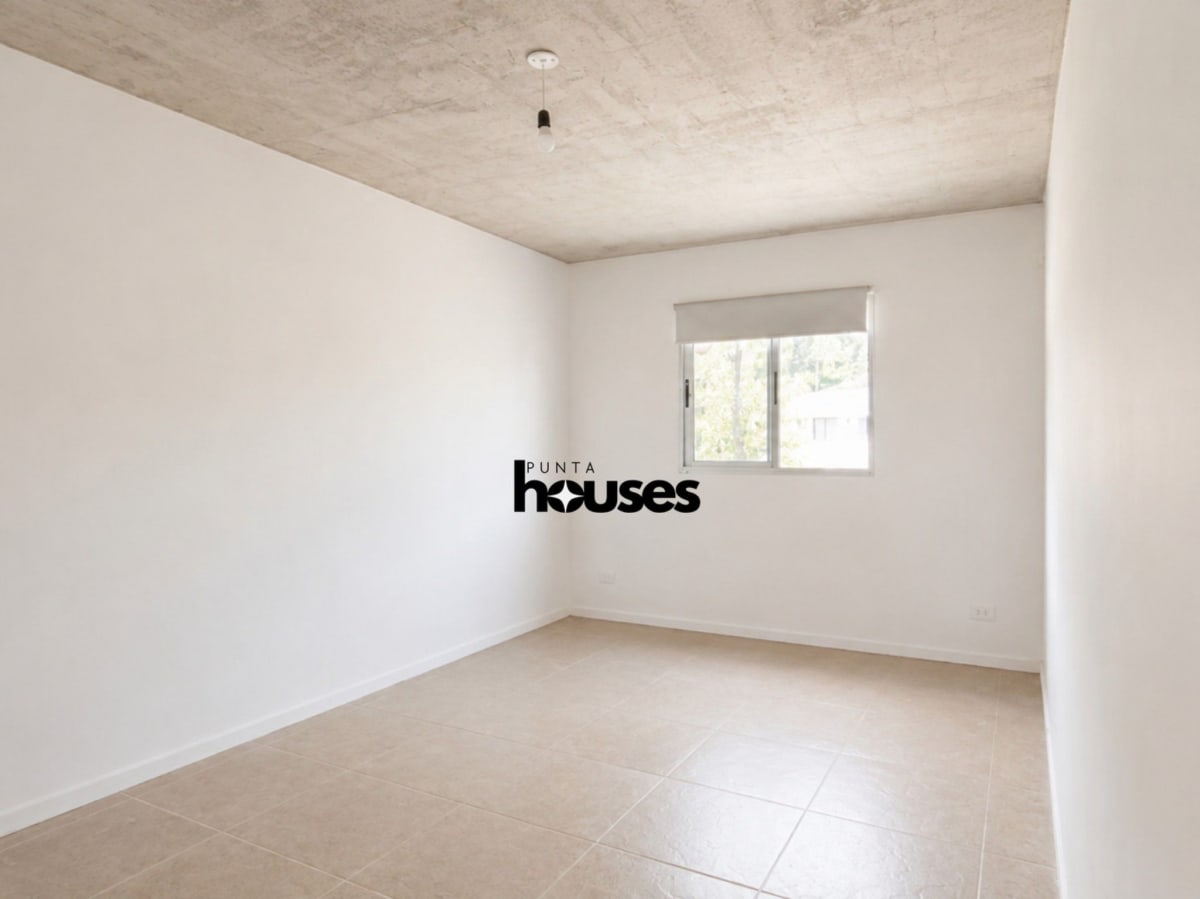 Unfurnished bedroom with roller blind, tiled floor and views of surrounding trees