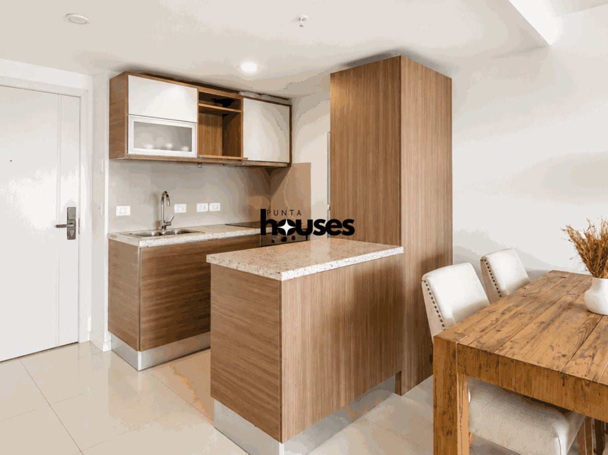 Modern integrated kitchen with wood cabinetry and breakfast counter in Gala Vista apartment Punta del Este.