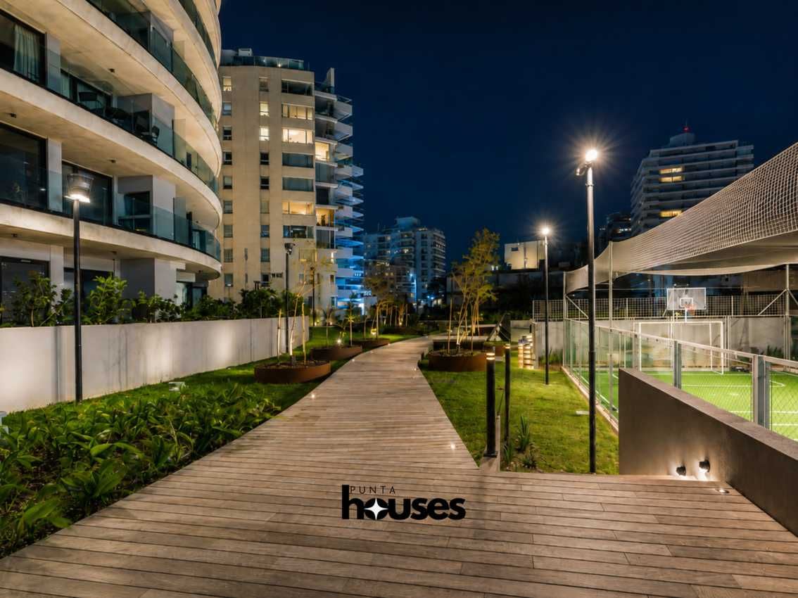 Landscaped communal gardens and multi-sport court at Manglar Brava residential building in Punta del Este.