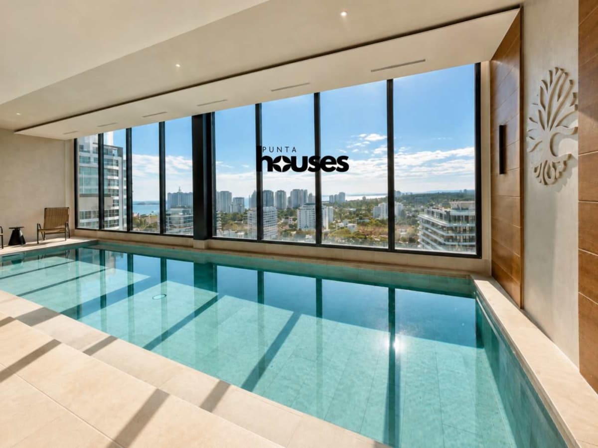 Heated indoor swimming pool with panoramic city views at Manglar Brava Punta del Este Uruguay.