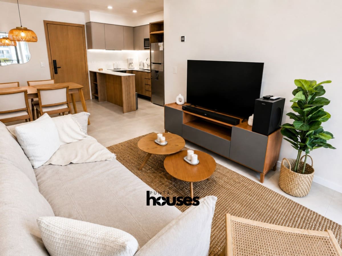 Bright furnished living room with dining area and modern open kitchen in Manglar Brava apartment near Playa Brava.