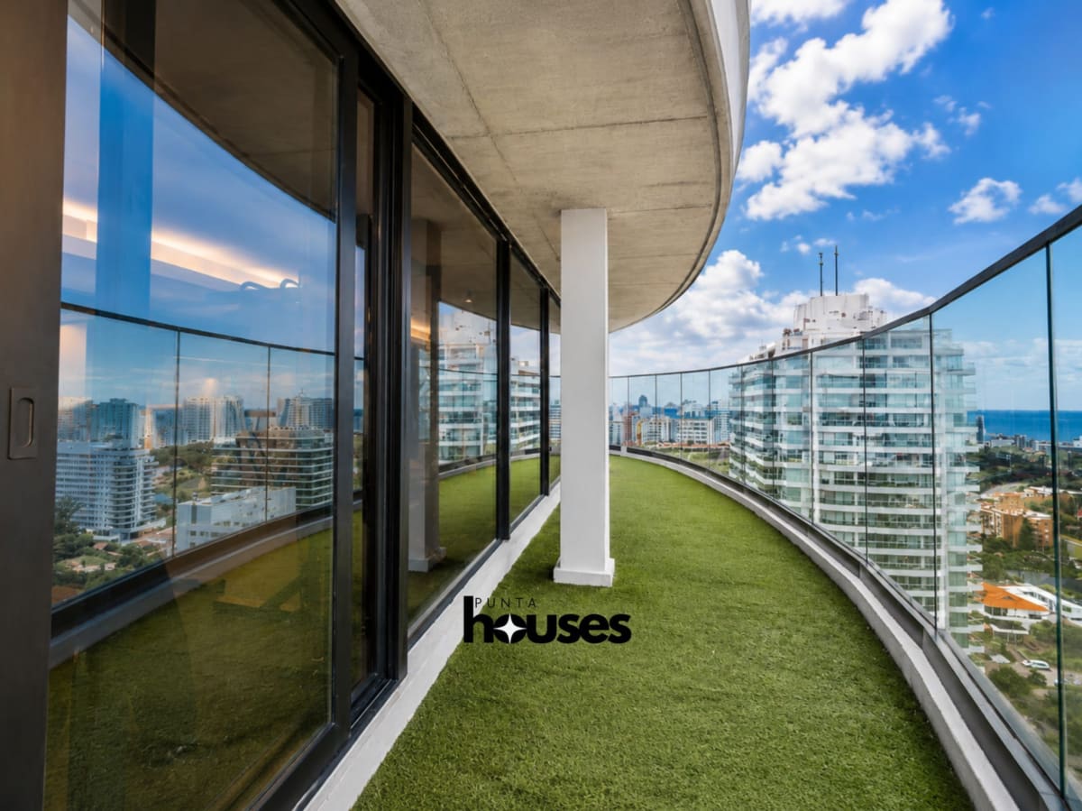 Curved rooftop terrace with glass railing and panoramic Punta del Este city views at Manglar Brava.