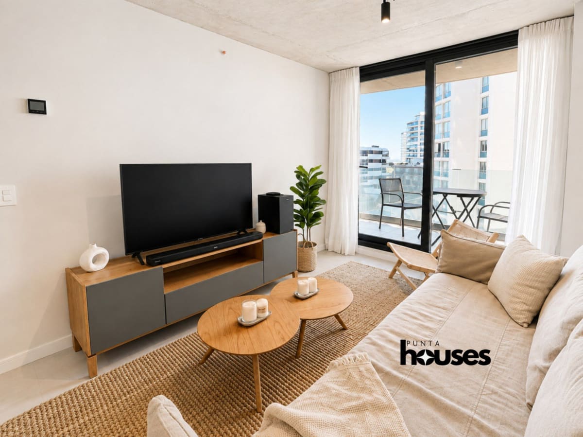 Modern furnished living room with private balcony in one-bedroom apartment at Manglar Brava Punta del Este.