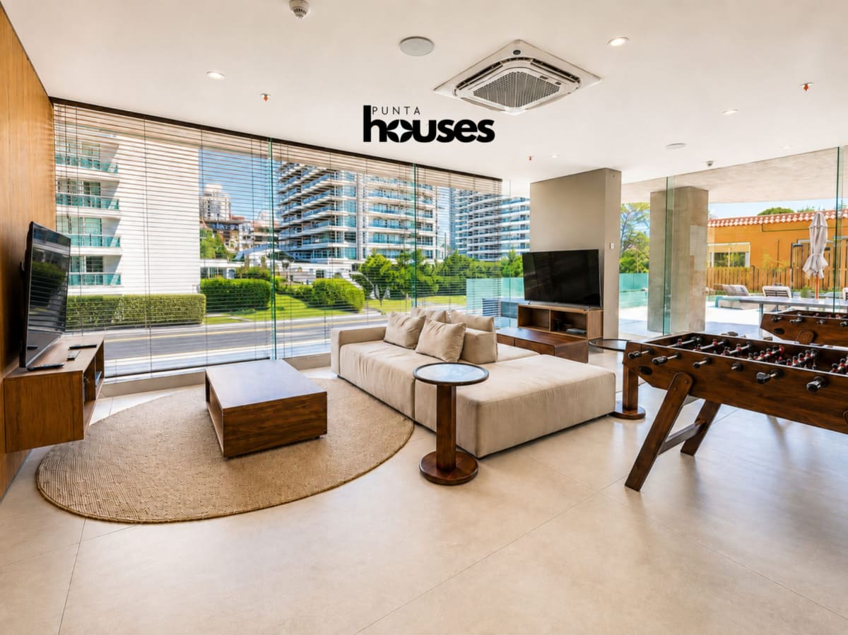 Spacious playroom with foosball table, lounge seating and large windows at Manglar Brava Punta del Este.