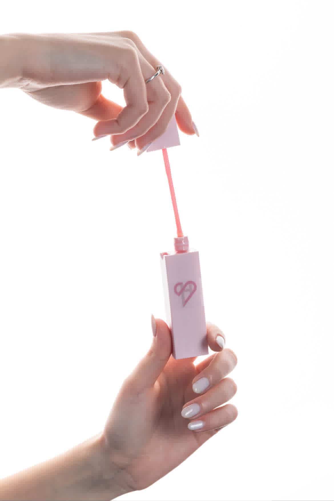 HerShield lip gloss — held in hand