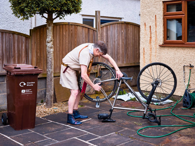Historical novelist Ben Kane adjusting his bike; Wells, Somerset, April 2023. Photograph Copyright © Simon Holliday