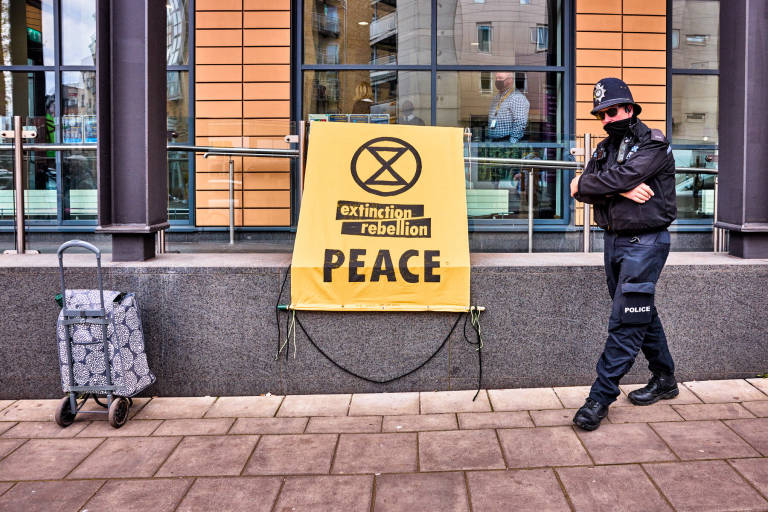 A police officer accidentally strikes a pose outside Bristol Magistrates&#039; Court during a vigil for the Reverend Sue Parfitt, who is appearing in court charged with obstruction of a highway during a protest outside the Ministry of Defence in Abbey Wood, Bristol, in December 2020. Photograph Copyright &copy; Simon Holliday