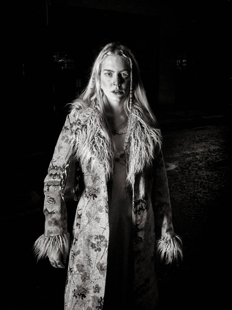 Maddie by construction site safety light, Nelson Street, Bristol, November 2021. Photograph Copyright © Simon Holliday