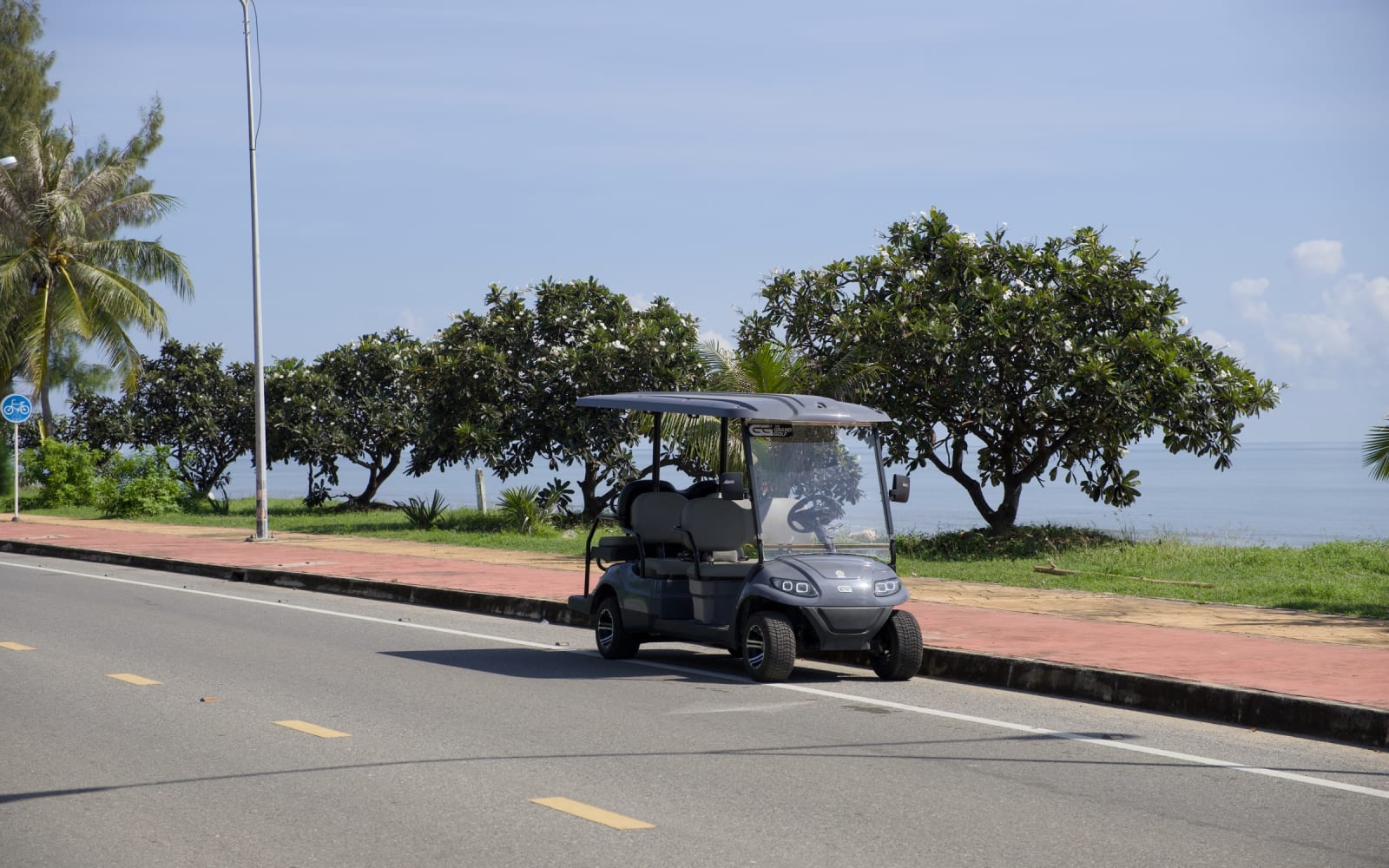 A golf-cart buggy on the Pak Nam Pran beach road by the sea
