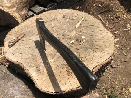 A hatchet lodged in a large piece of oak