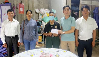 Phóng viên Báo Quảng Bình và đại diện chính quyền địa phương trao tiền hỗ trợ cho gia đình em Dương Thị Thu Hiền.