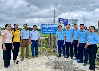 Cắm biển công nhận thôn đạt 100% người dân tham gia BHYT tại thôn Quảng Xá, xã Tân Ninh (Quảng Ninh).