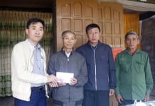 Phóng viên Báo Quảng Bình và đại diện chính quyền địa phương trao tiền hỗ trợ cho gia đình ông Nguyễn Đức Tính.