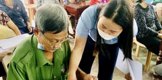 Cán bộ, nhân viên BHXH hướng dẫn người dân mở tài khoản để nhận lương hưu, trợ cấp BHXH qua thẻ ATM.
