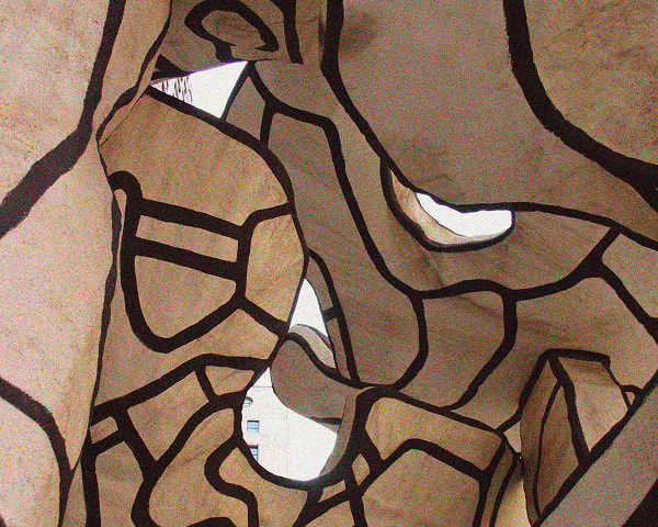 Abstract art installation featuring light brown organic shapes outlined in dark brown, with irregular openings revealing a bright background and parts of a building with windows.