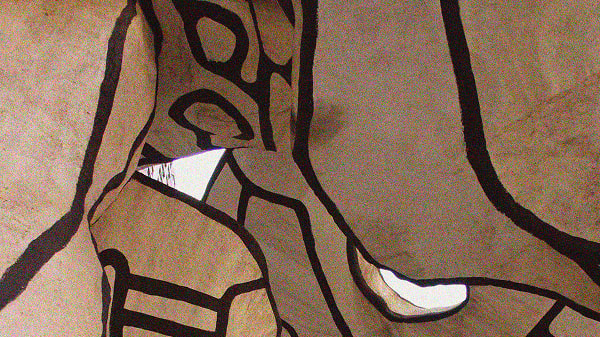 Abstract art installation featuring light brown organic shapes outlined in dark brown, with irregular openings revealing a bright background and parts of a building with windows.